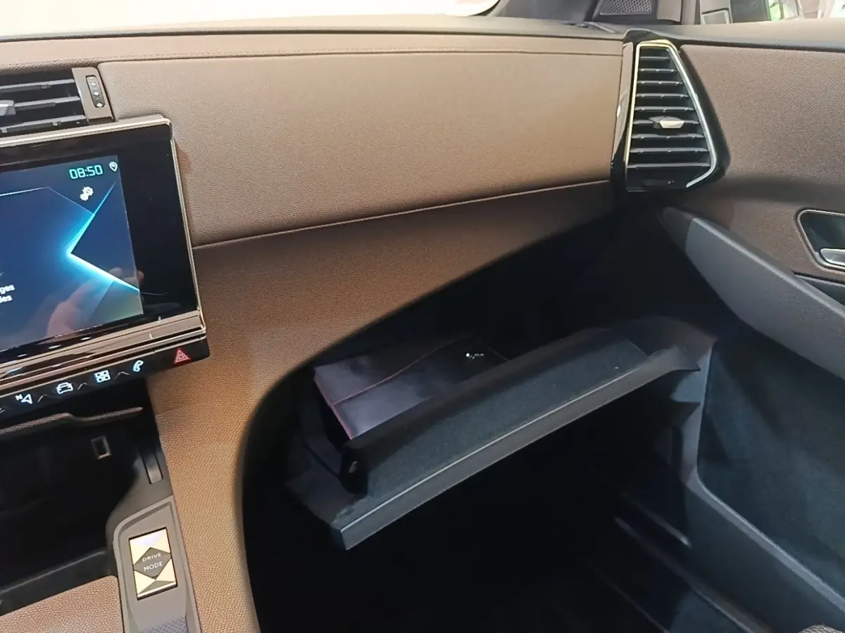 Intérieur de la DS7 Crossback E-TENSE 225 Business, vue côté passager sur la boîte à gants ouverte et écran tactile.