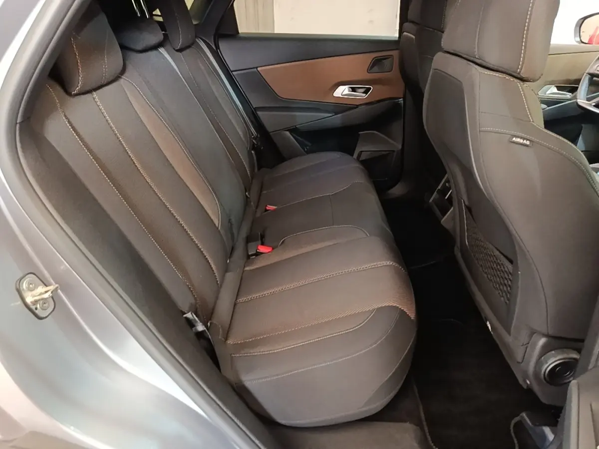 Vue intérieure côté gauche montrant la banquette arrière noire du DS7 Crossback E-TENSE 225 BUSINESS gris foncé.