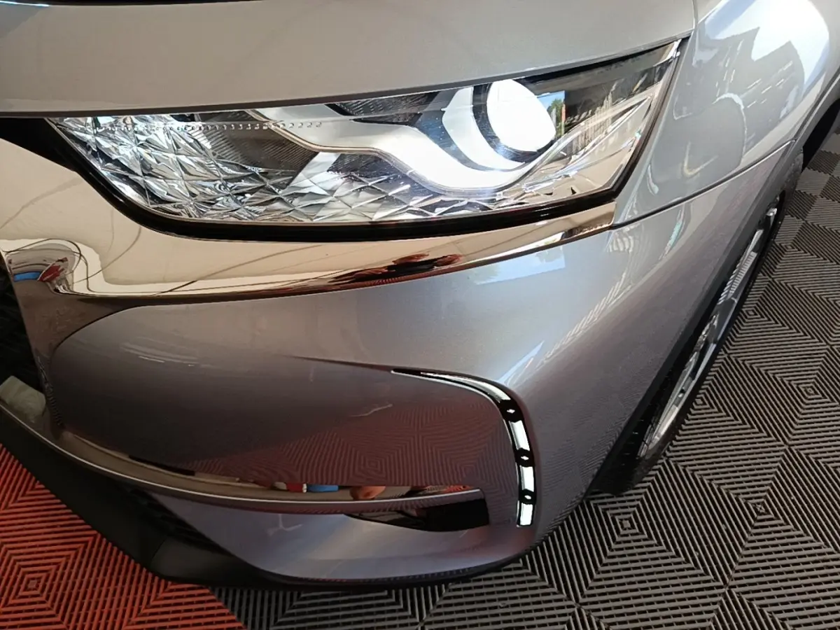 Gros plan sur le phare avant droit allumé d’un DS7 Crossback gris foncé avec éclairage LED diurne en forme de virgule.