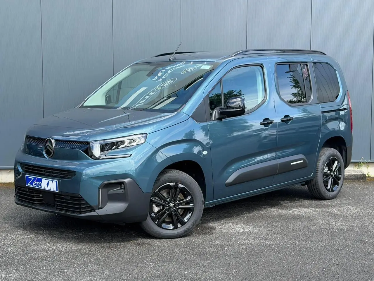 Citroën Berlingo Multispace bleu Kiama en 3/4 avant droit, avec jantes alliage noires et barres de toit.