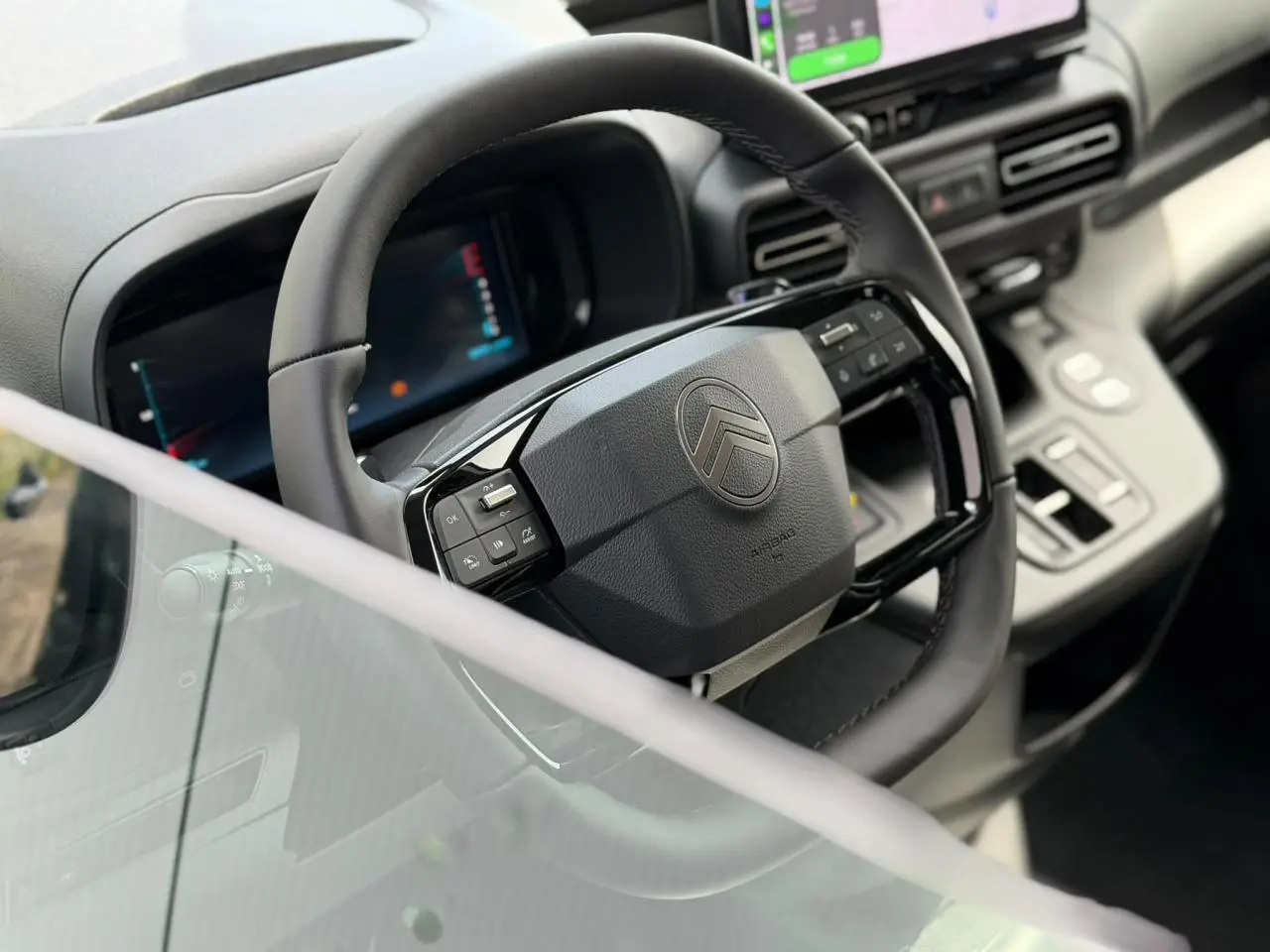 Vue intérieure rapprochée du volant multifonctions cuir et du combiné numérique du Citroën Berlingo Multispace 2026.