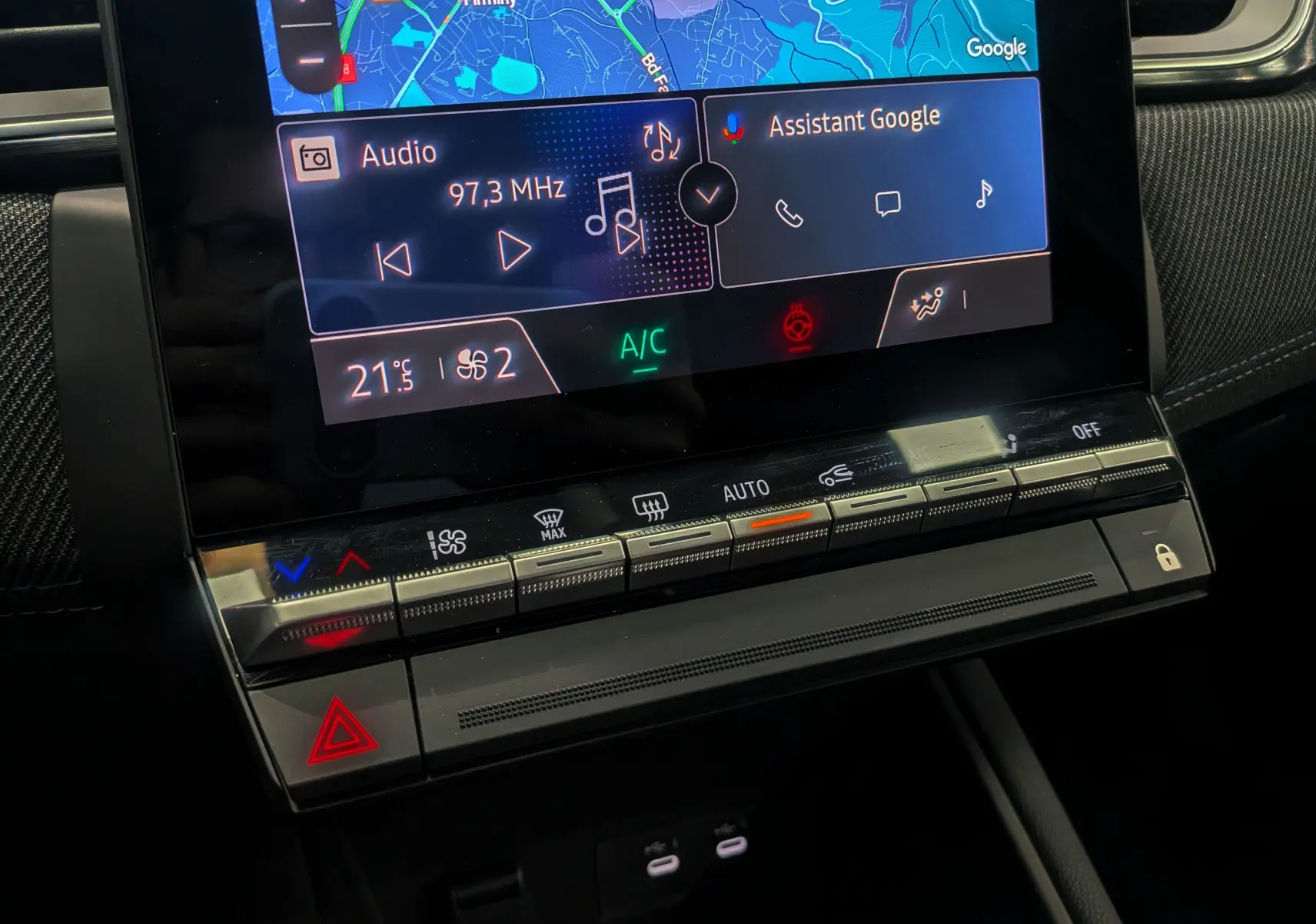 Détail de la console centrale du Renault Captur E-TECH 2025, avec écran tactile affichant navigation et commandes climatisation.