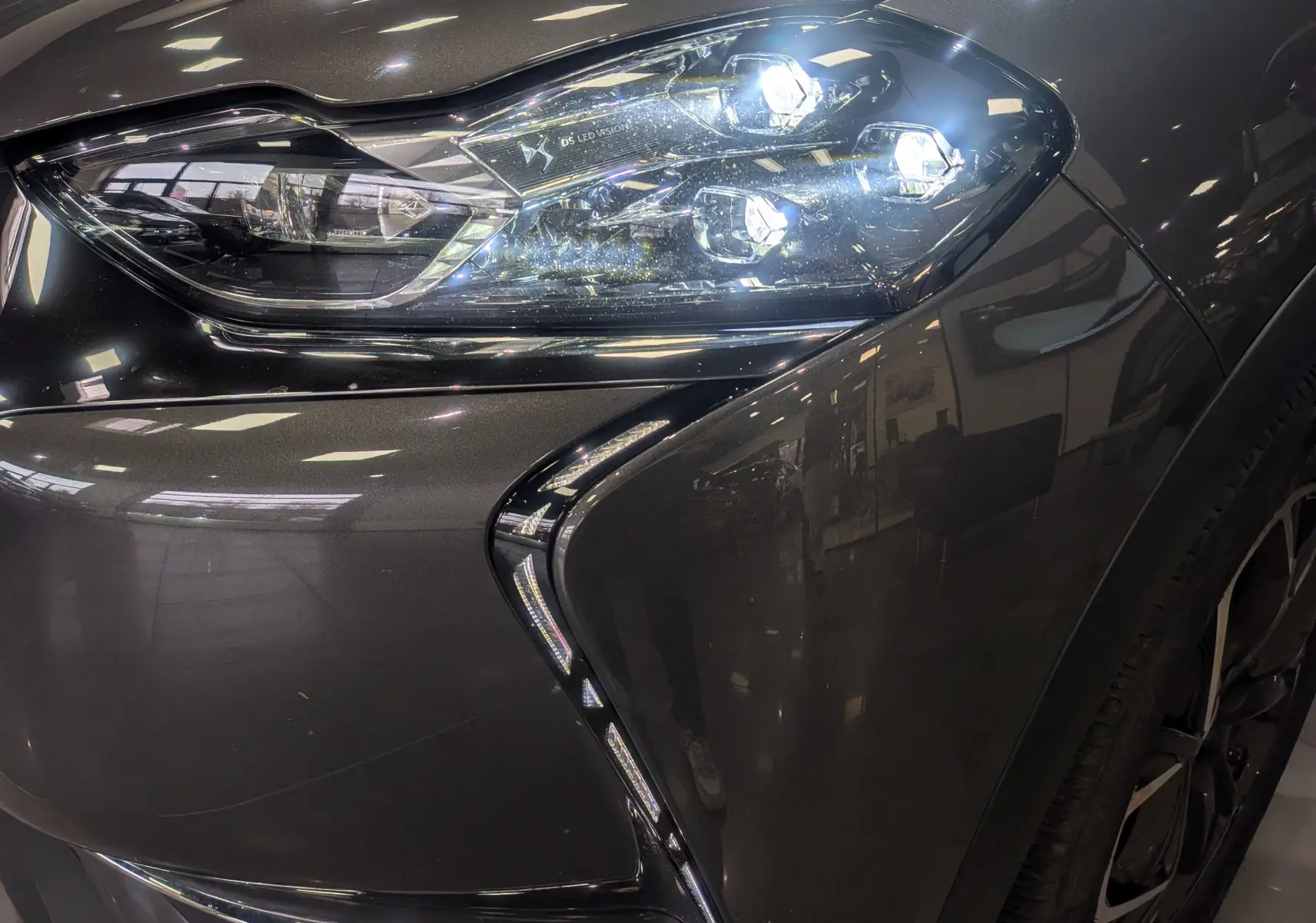 Gros plan sur le phare avant droit du DS3 Crossback gris Platinium avec toit noir, soulignant ses LED distinctives.