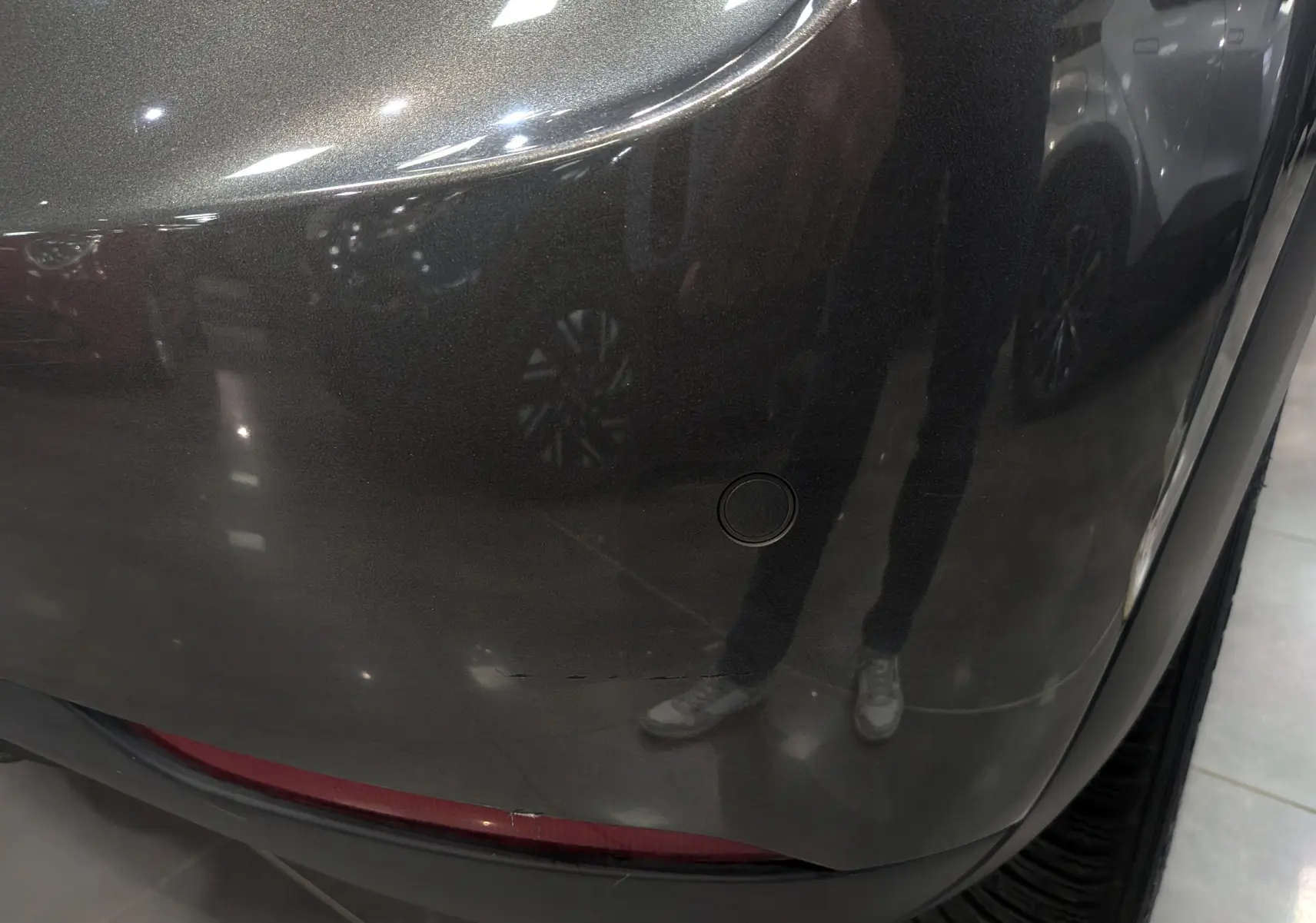 Gros plan sur le pare-chocs arrière gris Platinium du DS3 Crossback 2022 avec toit noir, montrant un capteur de stationnement.