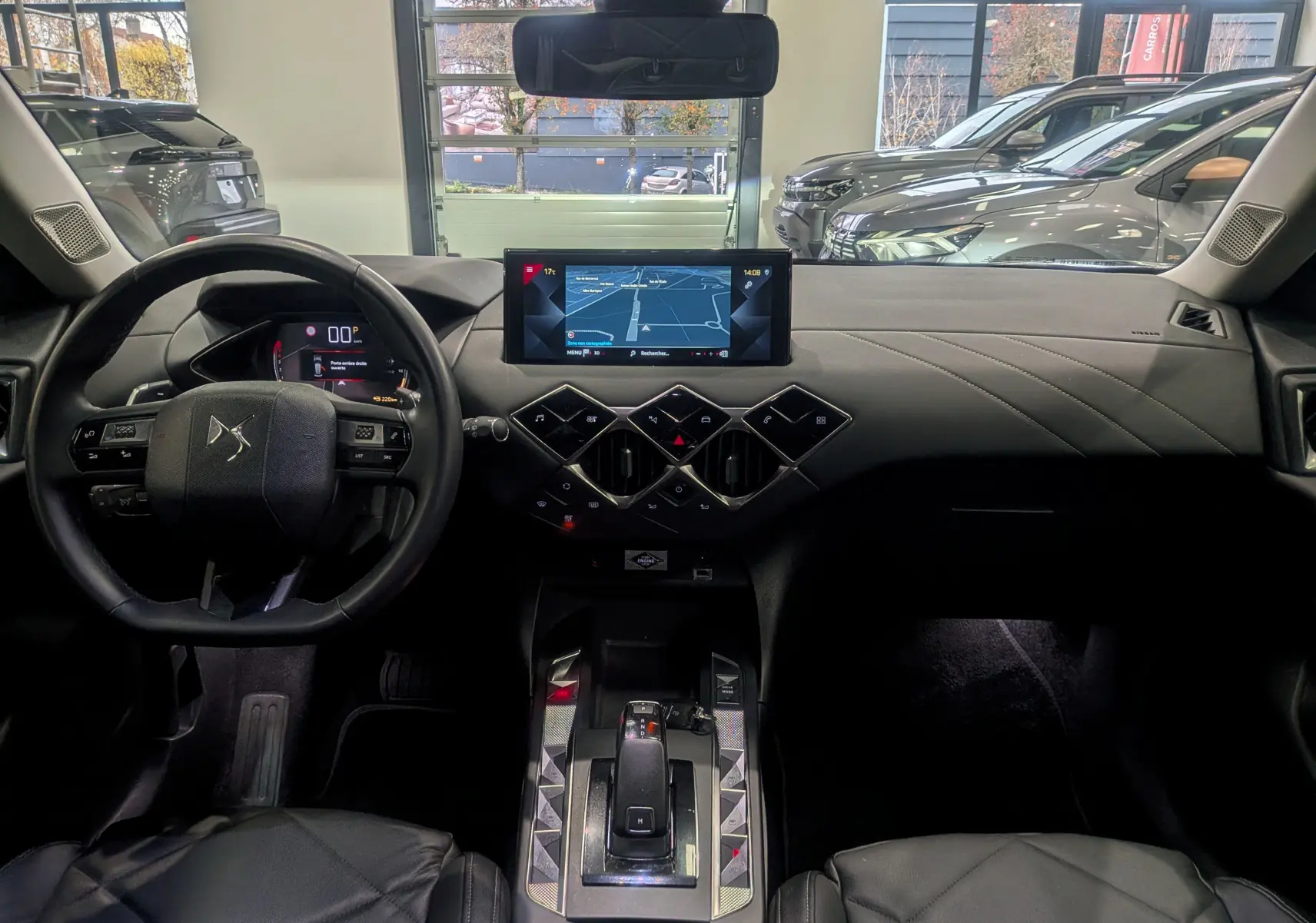 Vue intérieure avant du DS3 Crossback 2022, tableau de bord noir avec écran central et volant multifonction.