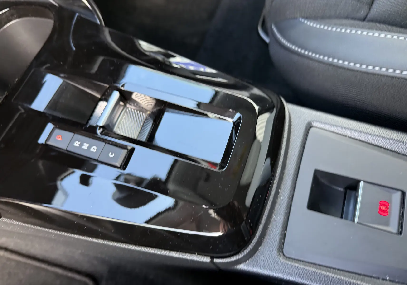 Gros plan sur la console centrale noire brillante avec sélecteur de boîte auto et frein à main électrique du Citroën C3 Aircross 2025.