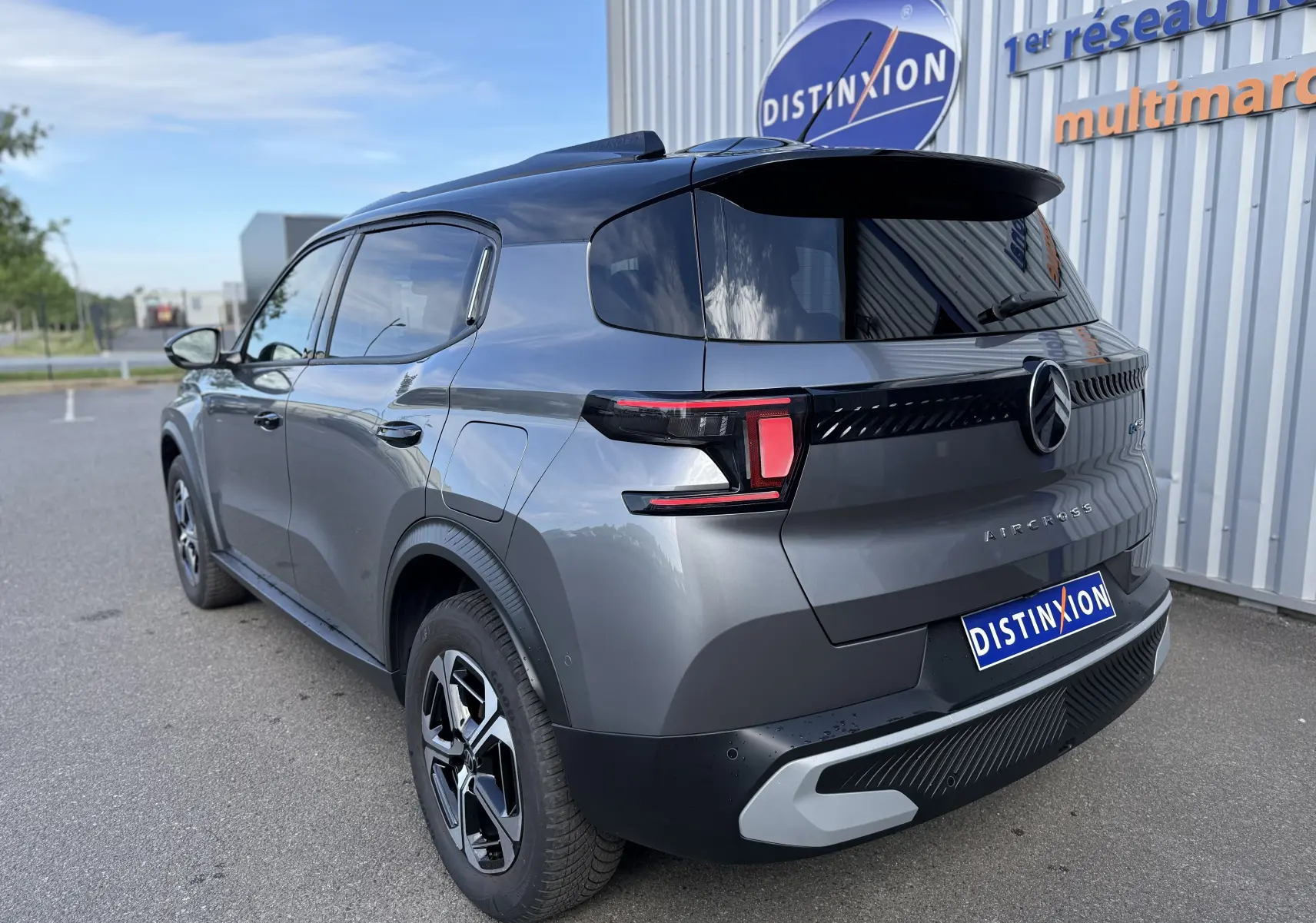 Vue 3/4 arrière droite d'un Citroën C3 Aircross électrique gris Mercury avec toit noir et feux arrière LED distinctifs.