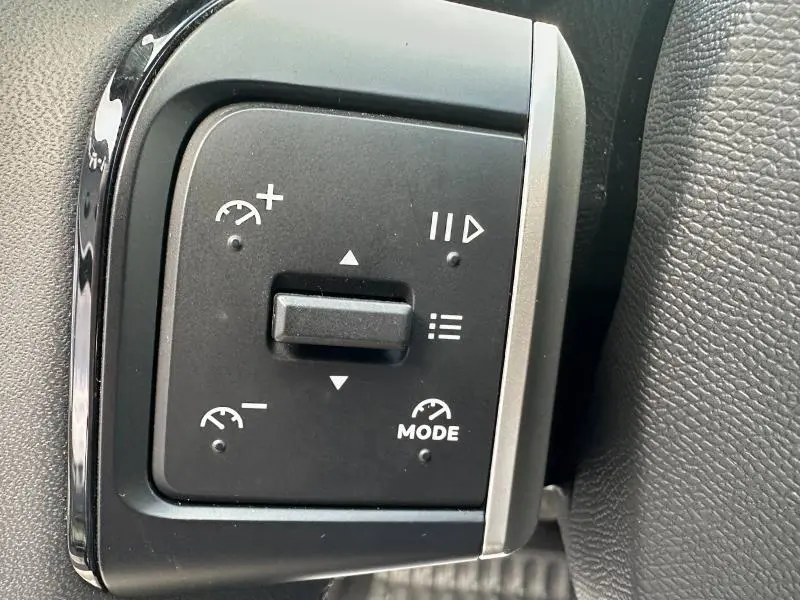 Gros plan sur les commandes au volant de la Citroën C3 1.2 Turbo 2025, avec boutons de régulateur de vitesse et mode.