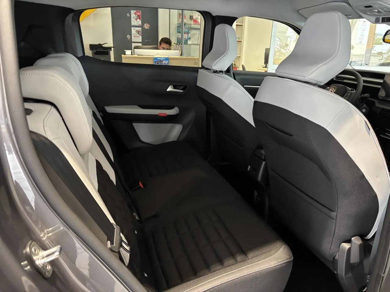 Vue intérieure côté gauche du Citroën C3 Aircross 2026, sièges arrière bicolores gris clair et noir avec appuie-têtes réglables.