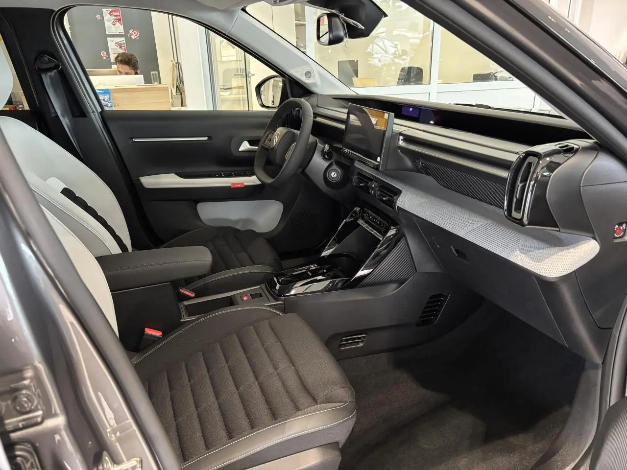 Vue intérieure côté conducteur du Citroën C3 Aircross 2026 gris, avec tableau de bord moderne et écran tactile central.