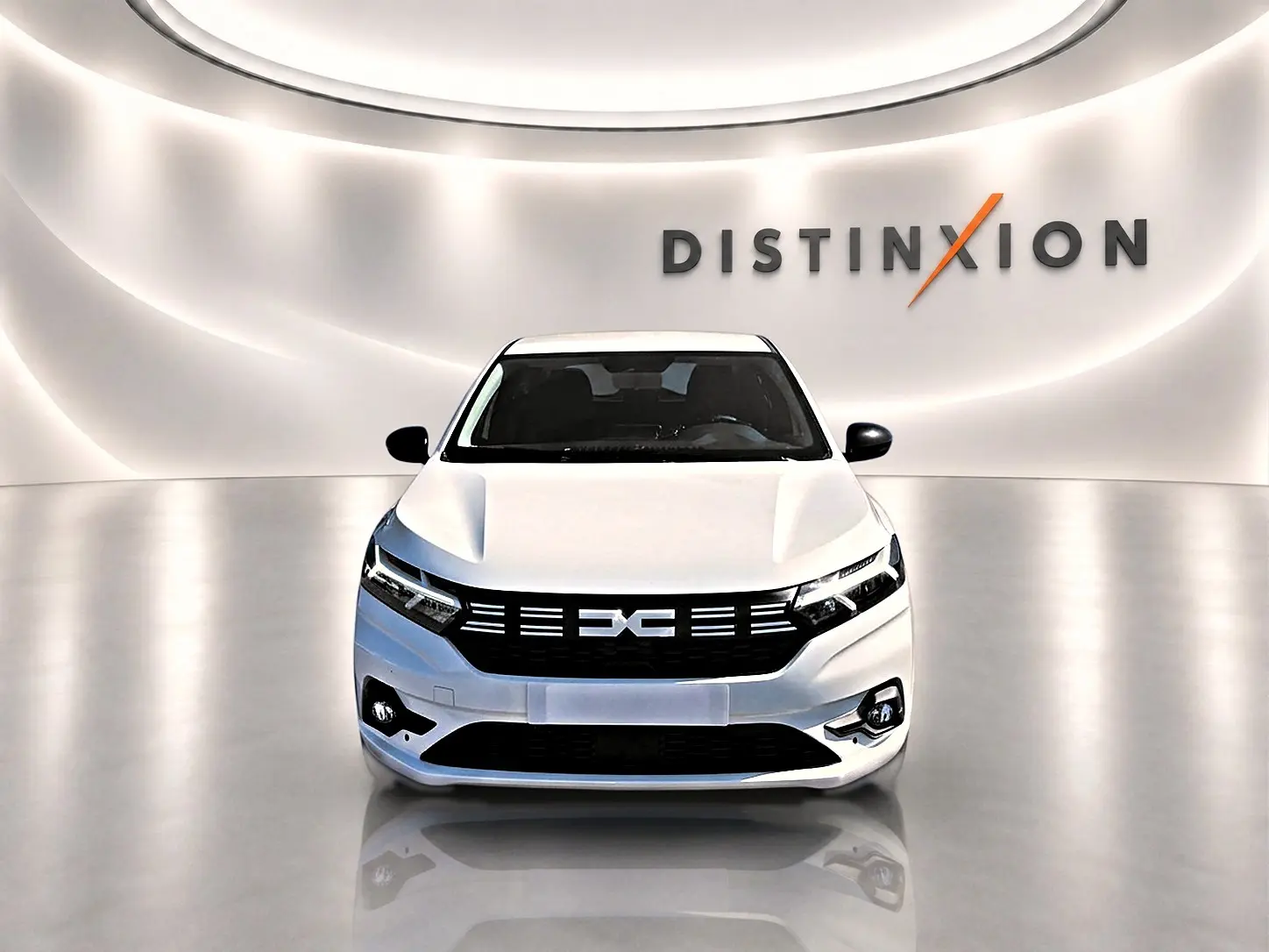 Vue frontale d'une Dacia Sandero blanche 2025 dans un showroom avec éclairage moderne et logo Distinxion en arrière-plan.