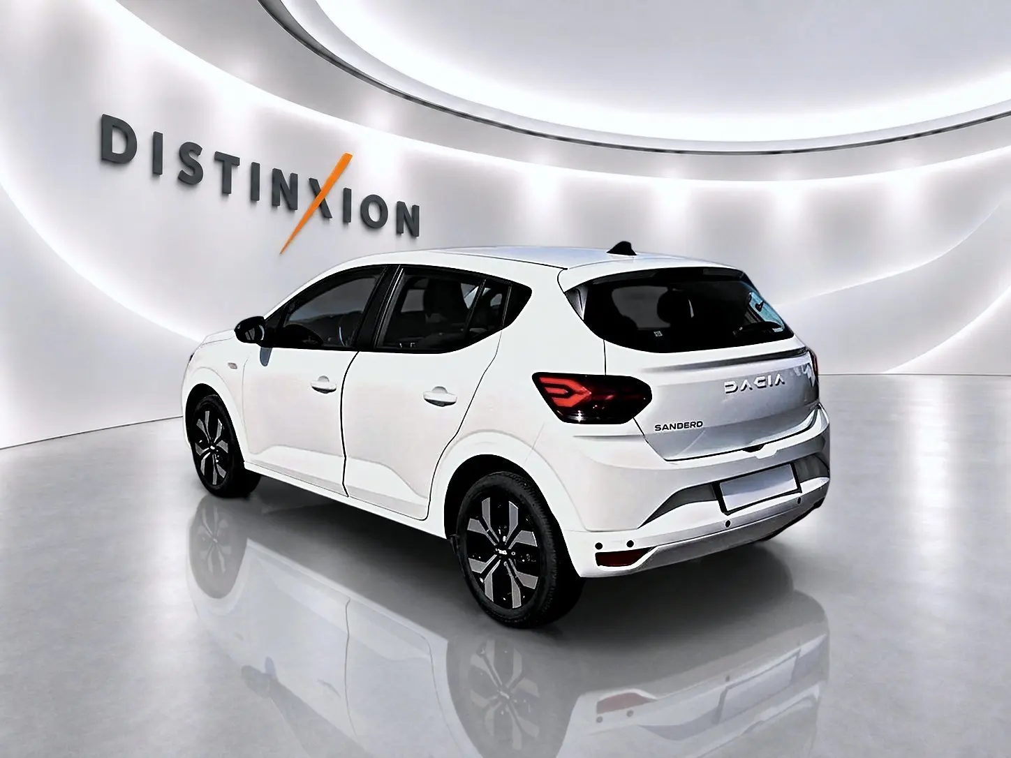 Vue 3/4 arrière droite d'une Dacia Sandero blanche 2025 avec jantes alliage et feux arrière LED distinctifs.