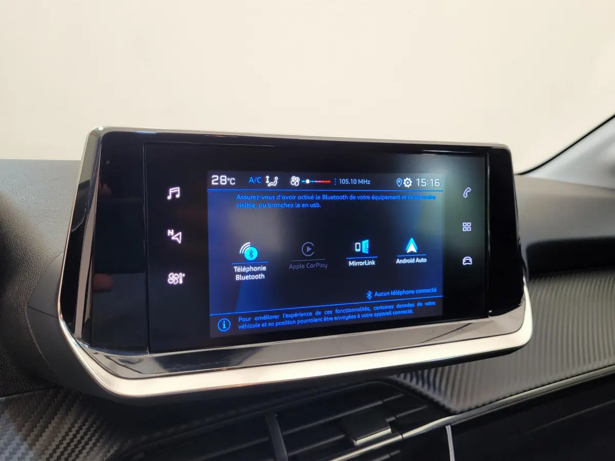 Écran tactile central de 7 pouces dans l'habitacle d'une Peugeot 208 gris foncé, affichant les options connectées Bluetooth et Apple CarPlay.