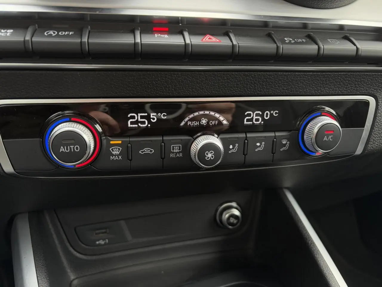 Gros plan sur la console centrale de l'Audi Q2 30 TFSI S-Line 2024, montrant la climatisation automatique bi-zone.
