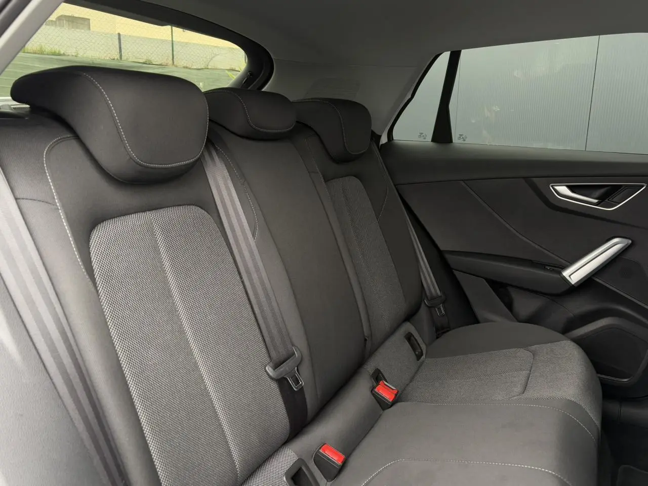 Vue intérieure côté droit des sièges arrière en tissu gris de l'Audi Q2 30 TFSI 110 S-Line 2024.