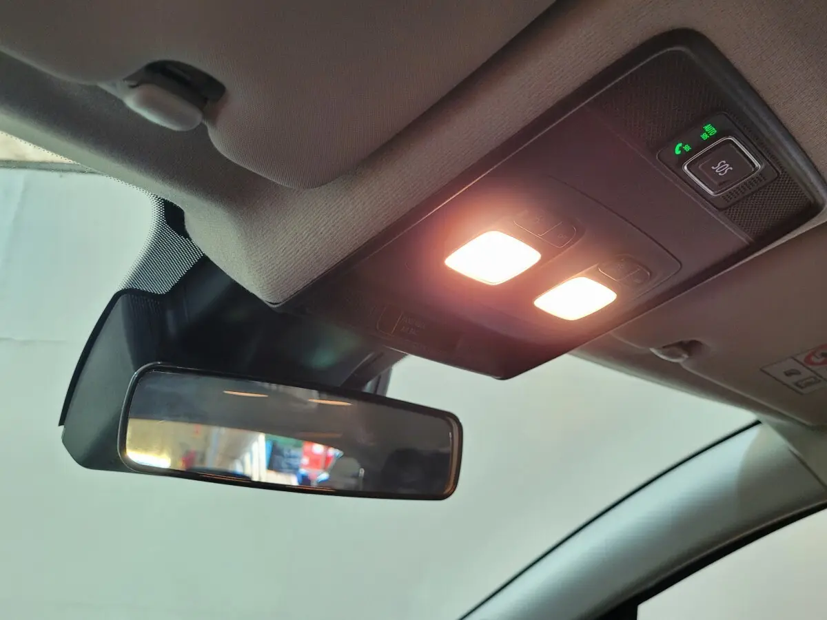 Vue intérieure du plafonnier avec éclairage et rétroviseur intérieur d'une Renault Clio gris foncé 2025.