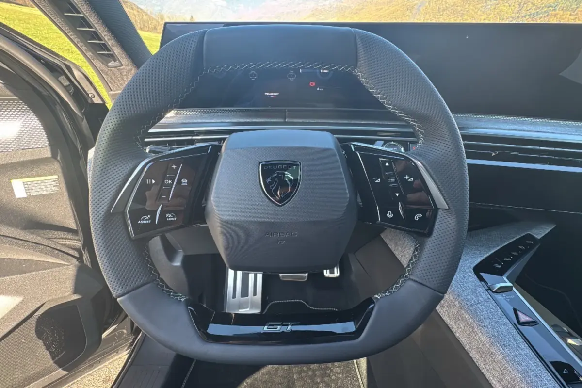 Vue rapprochée du volant cuir perforé noir avec logo Peugeot et insert GT du Peugeot 3008 New Hybrid 2025.