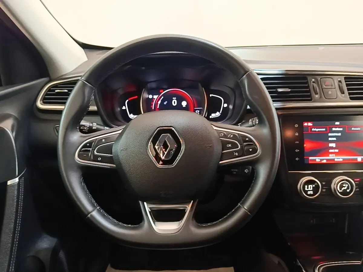 Vue intérieure centrée sur le volant multifonctions noir du Renault Kadjar 2021 avec tableau de bord numérique et écran tactile.