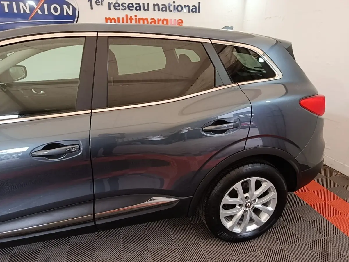 Vue latérale droite du Renault Kadjar Business gris foncé, mettant en valeur la porte arrière et la roue arrière.