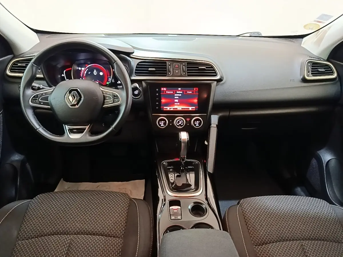 Vue intérieure avant du Renault Kadjar Business Blue dCi 115 EDC 2021, tableau de bord noir avec écran tactile central rouge.