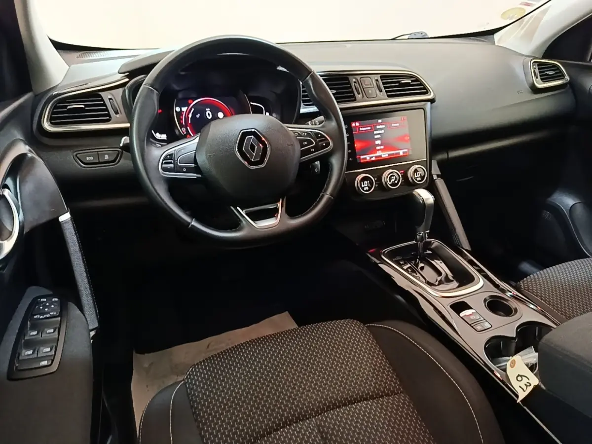 Vue intérieure du poste de conduite du Renault Kadjar 2021, avec volant multifonctions et écran tactile central allumé.