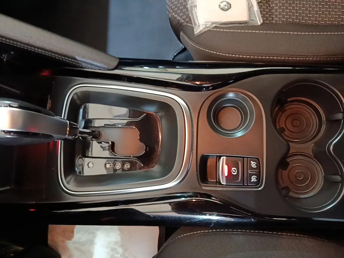 Vue plongeante sur la console centrale noire du Renault Kadjar 2021 avec levier de boîte auto et porte-gobelets.