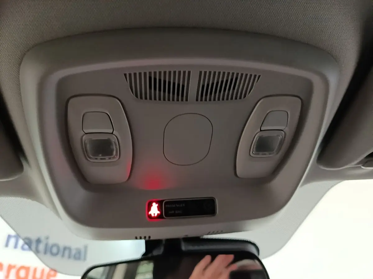 Plafonnier intérieur avec éclairage et témoin de ceinture allumé dans un Renault Kadjar gris foncé, vue vers l'avant.