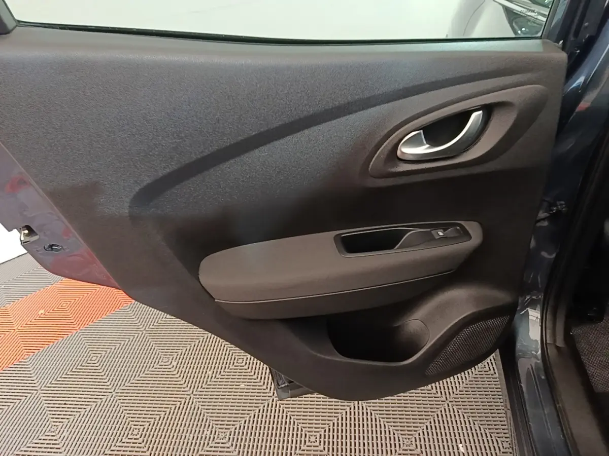 Vue rapprochée de la porte arrière droite gris foncé du Renault Kadjar 2021 avec poignée intérieure et commande de vitre.