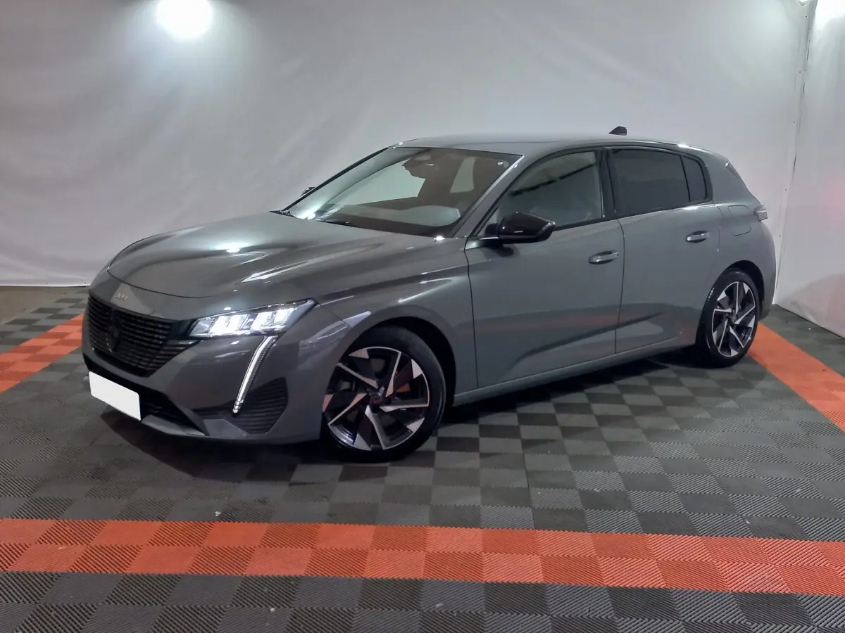 Peugeot 308 PHEV gris foncé vue 3/4 avant droit, avec feux LED et jantes alliage distinctives.