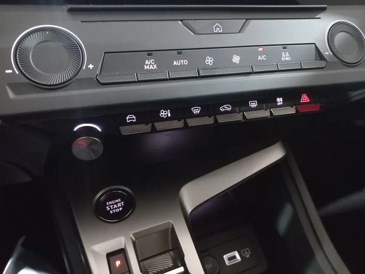 Détail de la console centrale de la Peugeot 308 PHEV 2025, avec commandes climatisation, bouton start/stop et ports USB.