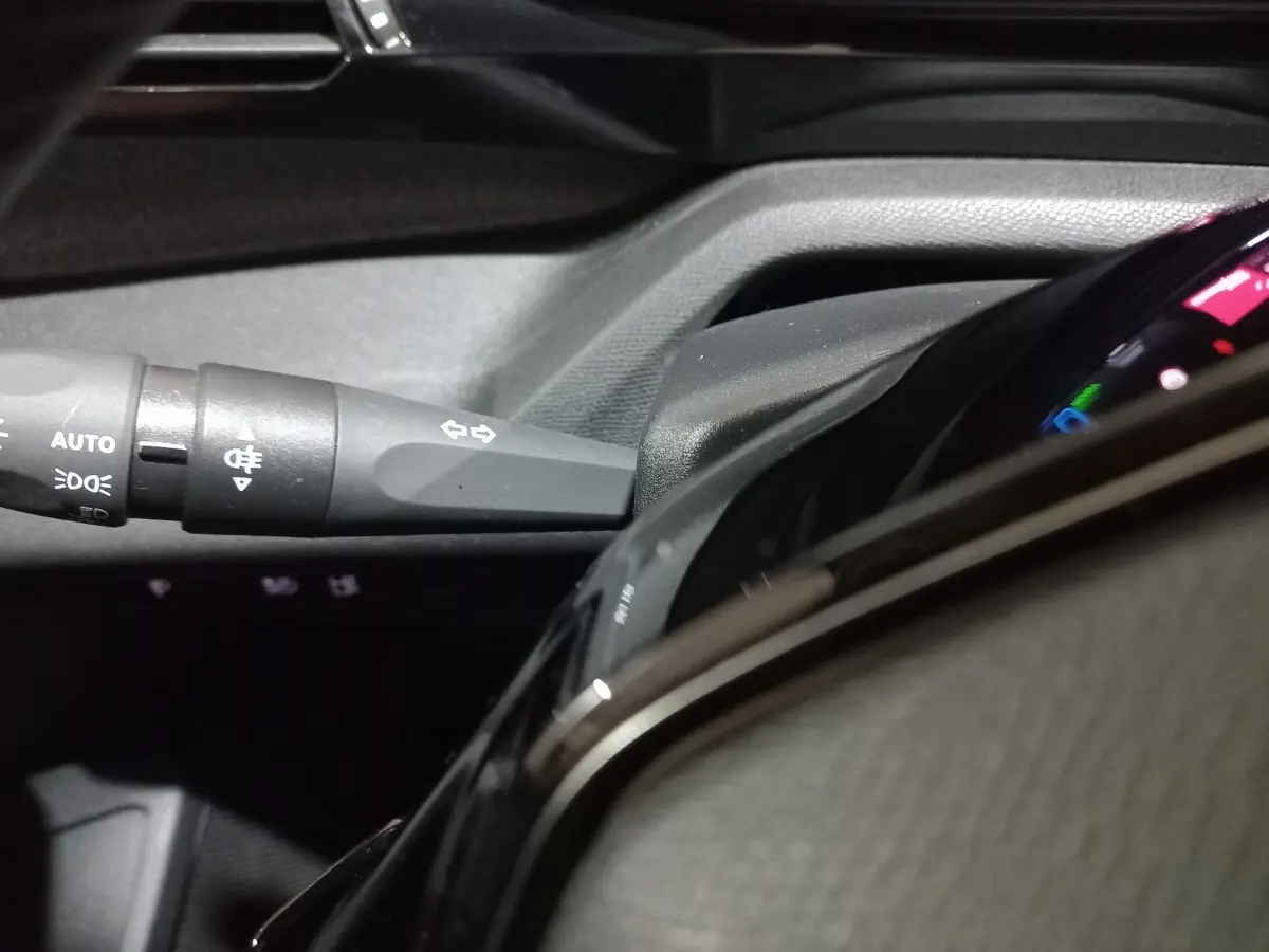Gros plan sur la commande des clignotants et partie du combiné d'instruments numérique du Peugeot 308 PHEV 180 E-EAT8 Allure.
