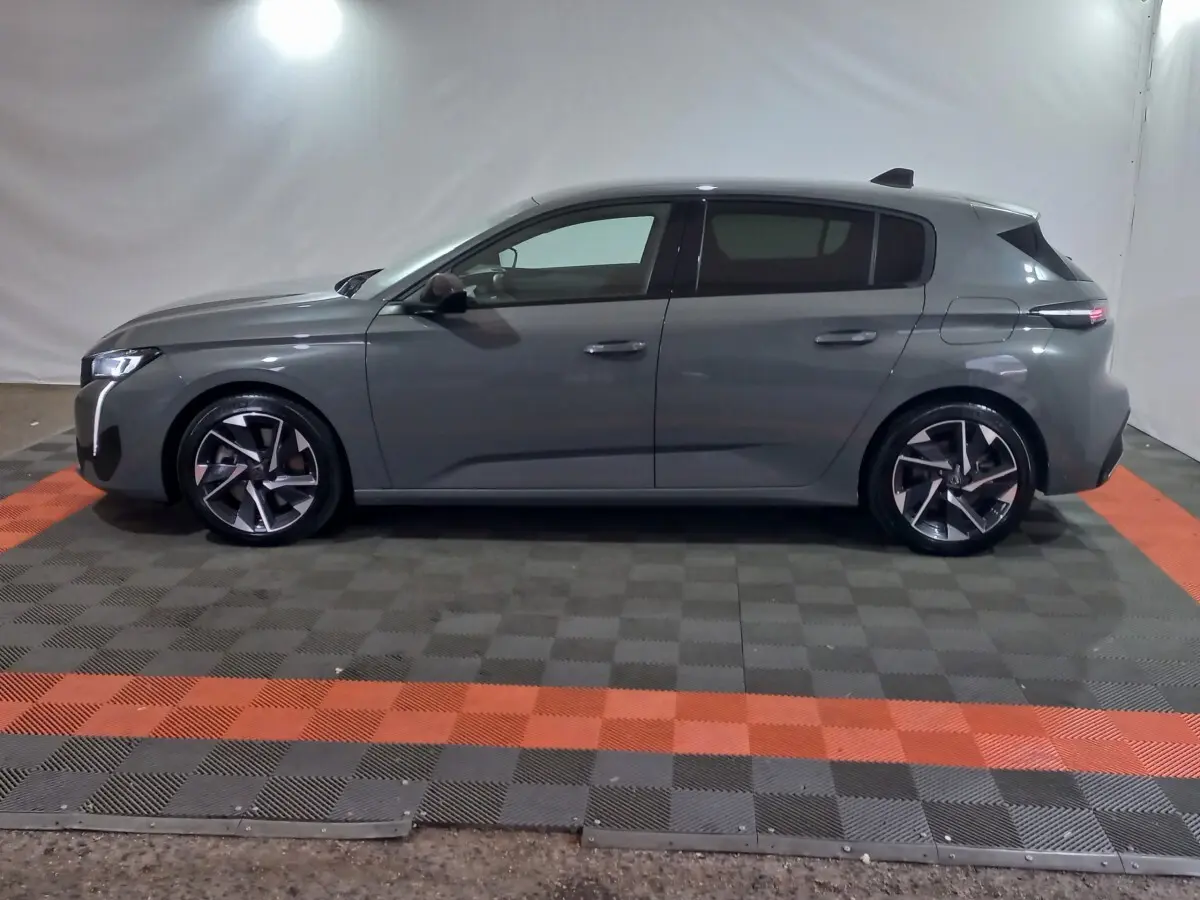 Peugeot 308 PHEV 180 gris foncé vue de profil côté gauche, avec jantes alliage et lignes modernes.