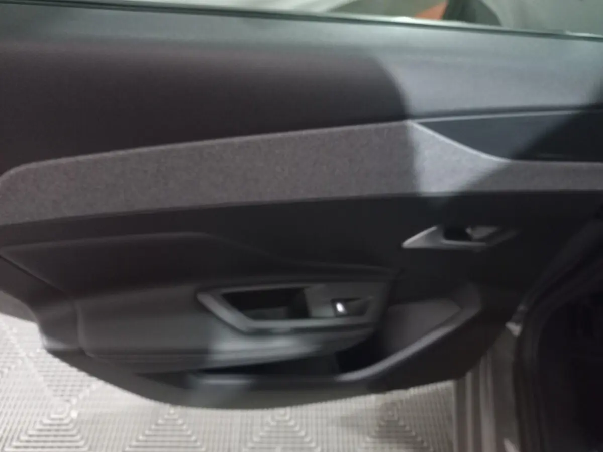 Vue intérieure de la porte côté droit de la Peugeot 308 PHEV 180 E-EAT8 Allure gris foncé, avec poignée intégrée.