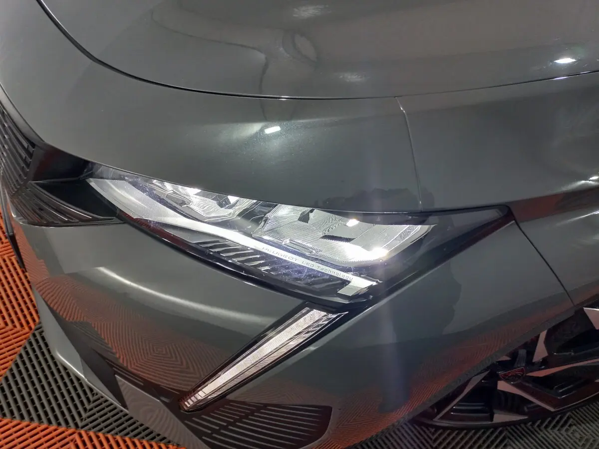 Gros plan sur le phare avant gauche LED d'une Peugeot 308 PHEV 180 E-EAT8 Allure gris foncé 2025.