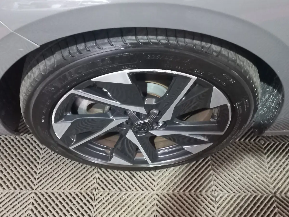 Gros plan sur la roue avant droite gris foncé de la Peugeot 308 PHEV 180 E-EAT8 Allure avec jante alliage moderne.