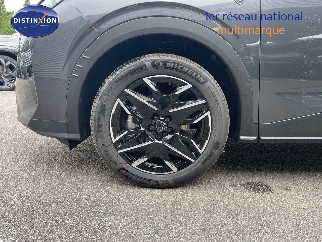 Gros plan sur la roue avant gauche du Peugeot 5008 gris titane métal avec jante alliage noire et argentée.