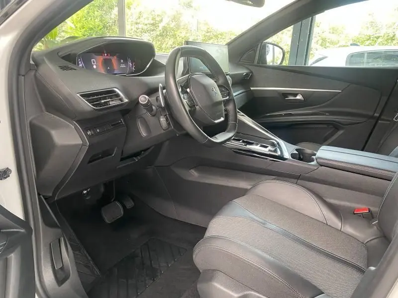 Intérieur côté conducteur du Peugeot 3008 blanc nacré 2023, volant cuir multifonction et tableau de bord numérique.