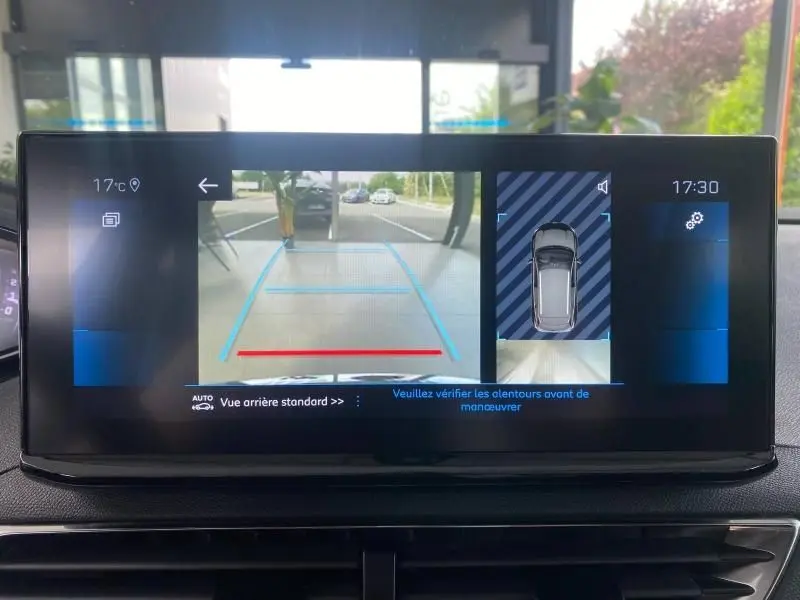 Écran tactile du Peugeot 3008 blanc nacré montrant la caméra de recul et l'aide au stationnement en vue arrière.