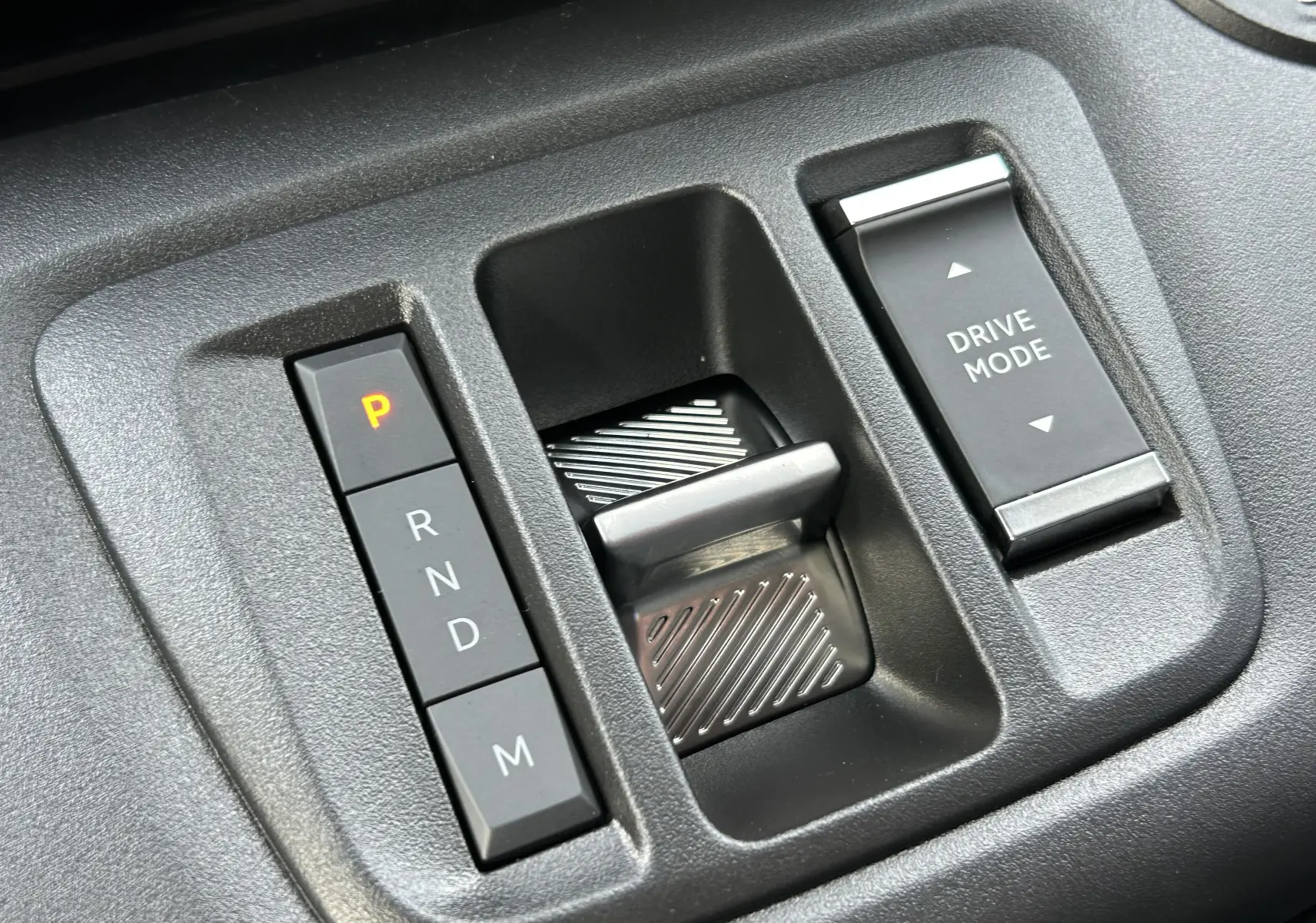 Gros plan sur la commande de boîte automatique et le bouton Drive Mode du Peugeot Partner Fourgon blanc 2025.