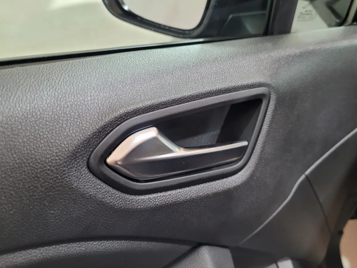 Poignée de porte intérieure côté gauche en plastique noir et métal dans une Renault Clio gris foncé Evolution Blue dCi 100 2025.