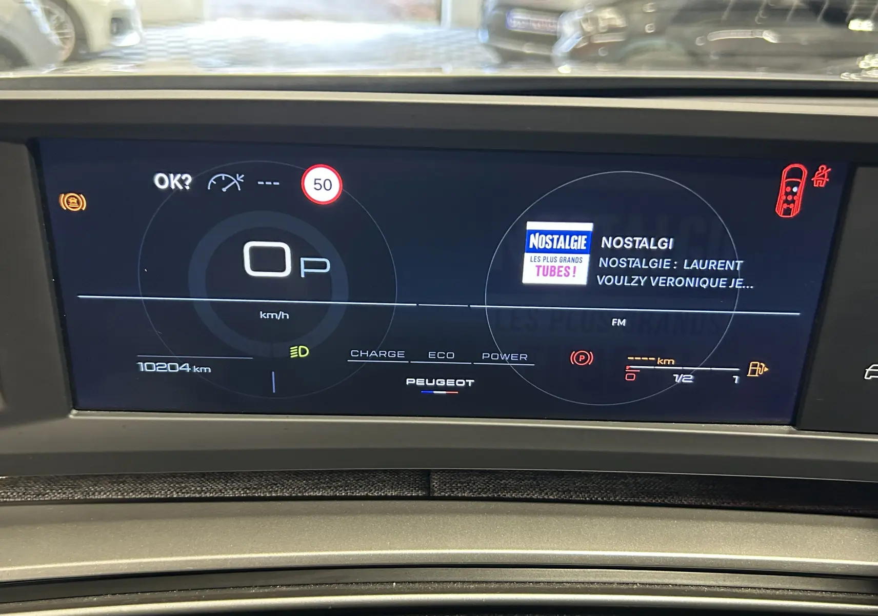 Affichage numérique du tableau de bord du Peugeot 5008 hybride 2025, avec écran noir et informations de conduite visibles.