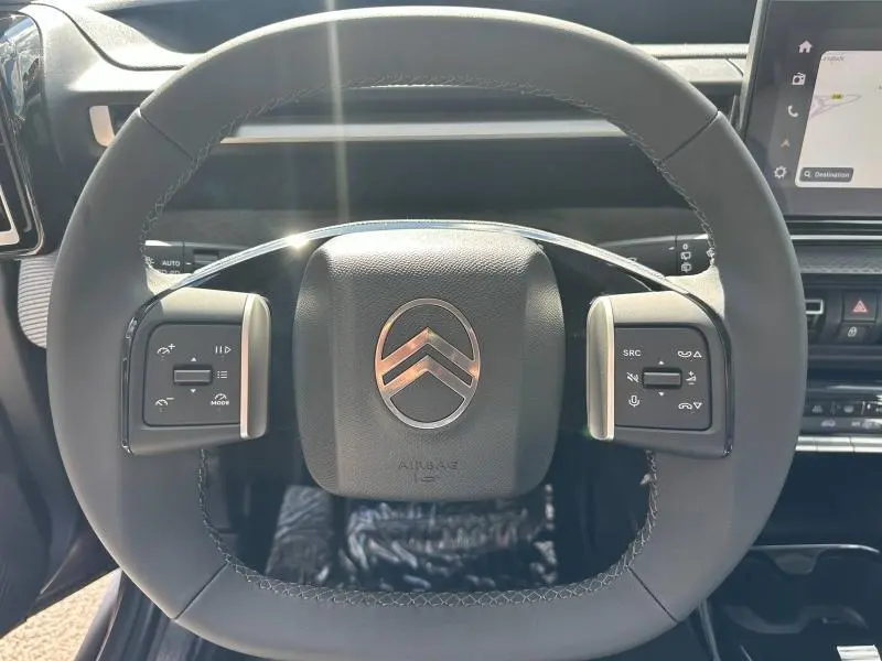Vue rapprochée du volant multifonction noir de la Citroën C3 Aircross 2026 avec logo chromé au centre.