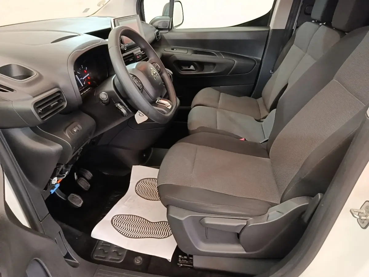 Vue intérieure côté conducteur du Citroën Berlingo blanc 2020, montrant les sièges et le tableau de bord moderne.