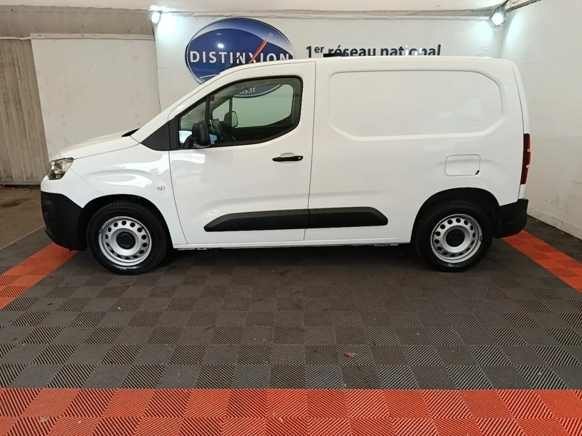Vue de profil côté gauche d’un utilitaire Citroën Berlingo blanc avec porte latérale pleine et jantes acier.