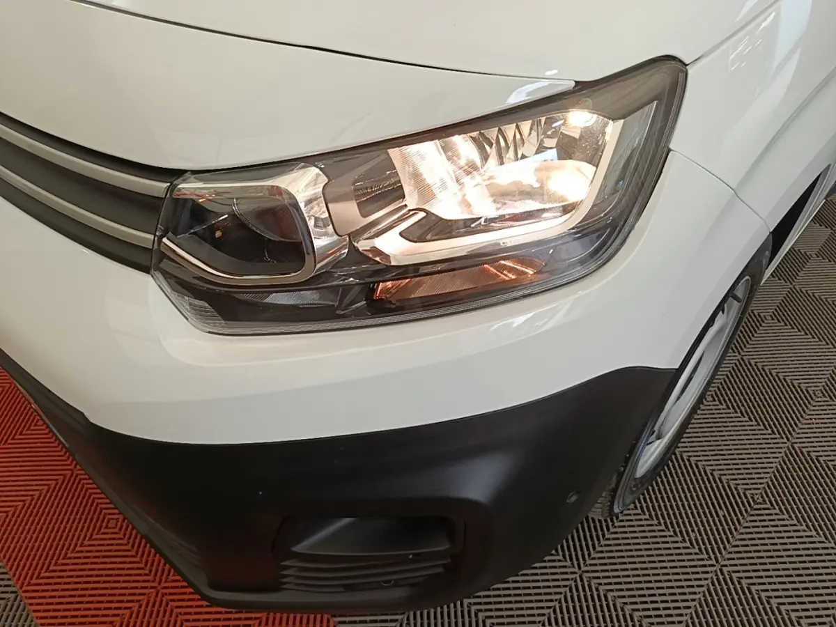 Gros plan sur l'avant droit blanc du Citroën Berlingo 2020 avec phare allumé et pare-chocs noir.