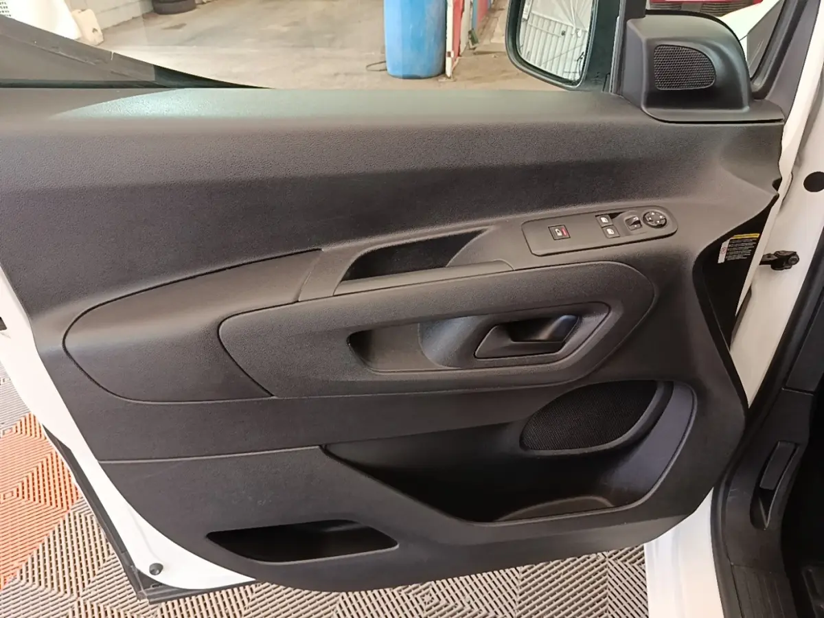 Vue intérieure côté gauche de la porte avant blanche du Citroën Berlingo 2020 avec commandes électriques et haut-parleur intégré.