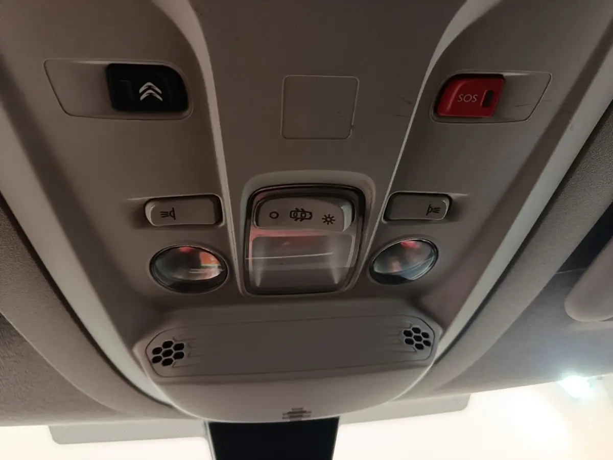 Plafonnier intérieur beige du Citroën Berlingo 2020 avec boutons d’éclairage, alarme SOS et haut-parleurs intégrés.