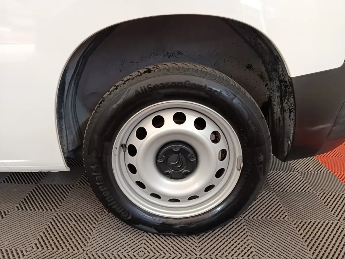 Gros plan sur la roue arrière droite d’un Citroën Berlingo blanc, jante acier avec pneu Continental AllSeasonContact.