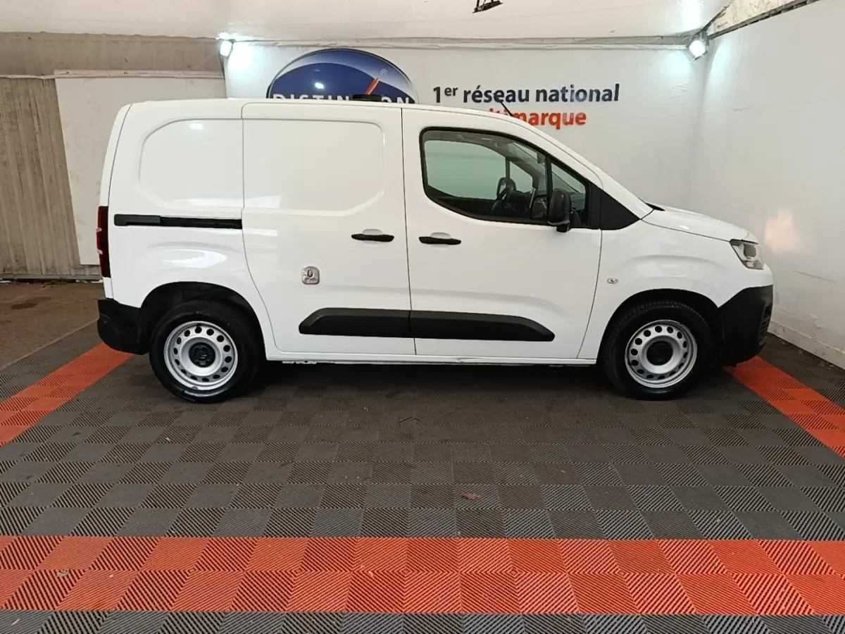 Vue latérale droite d’un utilitaire Citroën Berlingo blanc, avec portes latérales pleines et jantes acier simples.