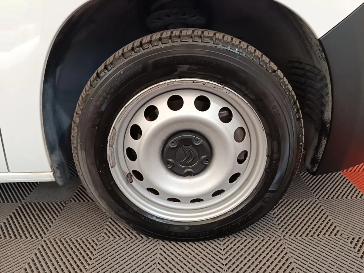 Gros plan sur la roue avant droite blanche d’un Citroën Berlingo 2020 avec jante acier et logo Citroën central.